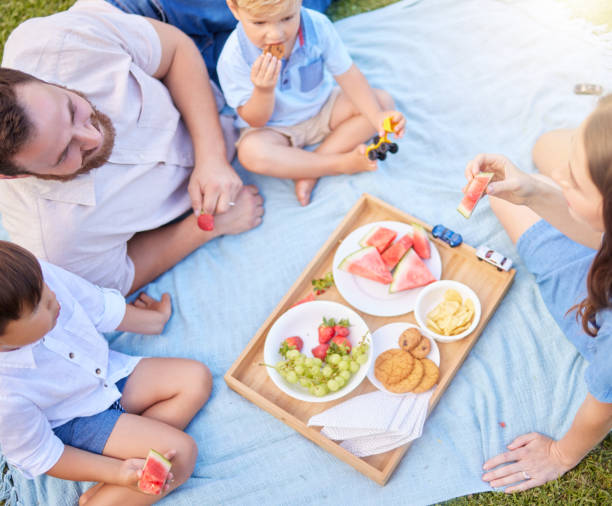 shot of a young family having a picnic at the park - lanche da tarde imagens e fotografias de stock