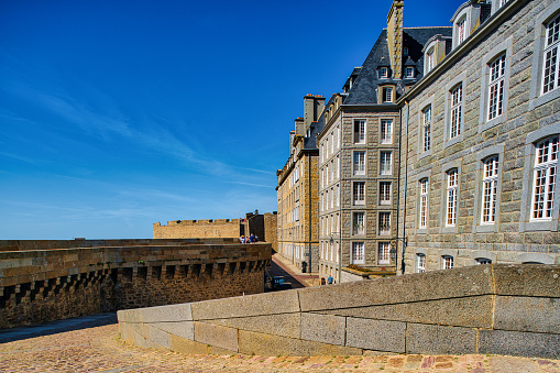 Saint-Malo, France, August 30, 2019: Looking at the walls who surroundet the famous city of Saint-Malo. It is a historic French port in Ille-et-Vilaine, Brittany on the English Channel coast. The city had a long history of piracy, earning much wealth from local extortion and overseas adventures. The city changed into a popular tourist centre, with a ferry terminal serving the Channel Islands of Jersey and Guernsey, as well as the Southern English settlements of Portsmouth, Hampshire and Poole, Dorset.