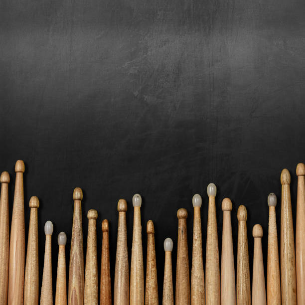 Group of Wooden Drumsticks on a Blackboard with Copy Space Close-up of a large group of wooden drumsticks on a black chalkboard with copy space. Percussion instrument banner. drum line stock pictures, royalty-free photos & images