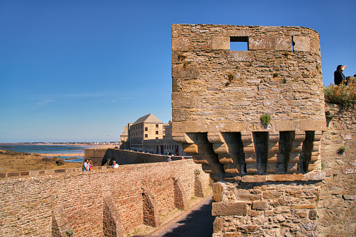 Saint-Malo, France, August 30, 2019: Looking at the walls who surroundet the famous city of Saint-Malo. It is a historic French port in Ille-et-Vilaine, Brittany on the English Channel coast. The city had a long history of piracy, earning much wealth from local extortion and overseas adventures. The city changed into a popular tourist centre, with a ferry terminal serving the Channel Islands of Jersey and Guernsey, as well as the Southern English settlements of Portsmouth, Hampshire and Poole, Dorset.