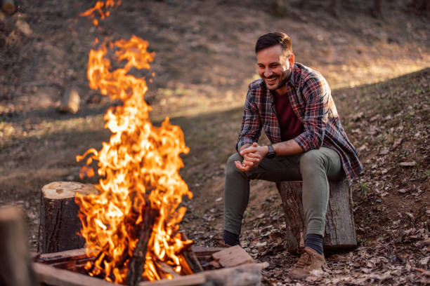 istock The smiling man, sitting alone around the campfire. 1390048531