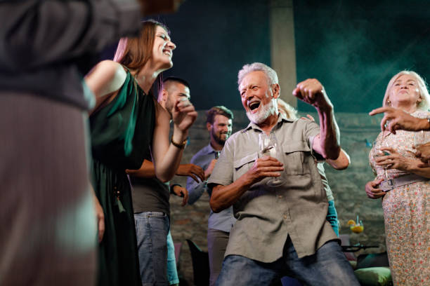 istock Senior man dancing with young people in a club. 1390050207