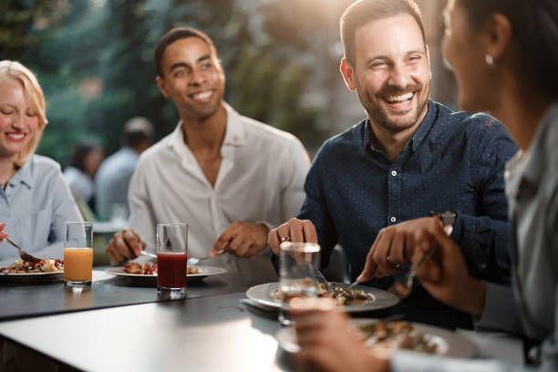 식당에서 점심을 즐기면서 이야기하는 행복한 동료 그룹. - smart casual outdoors friendship happiness 뉴스 사진 이미지