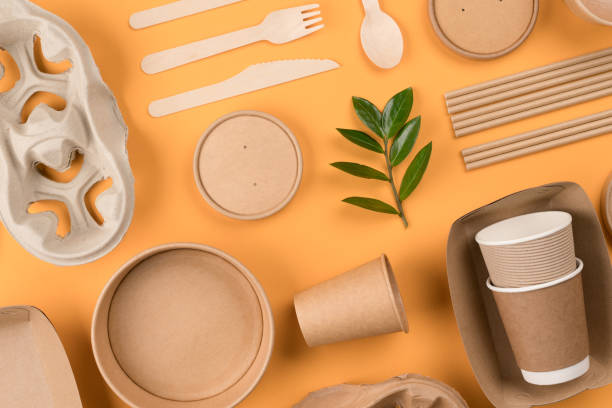 istock Flat lay composition with eco-friendly tableware - kraft paper utensils on orange background. Street food paper packaging, recyclable paperware, zero waste packaging concept 1390050934