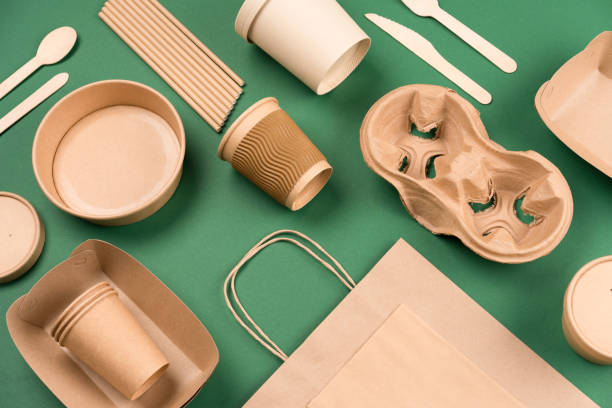 utensílios de papel kraft em fundo verde. copos de papel e recipientes, talheres de madeira. embalagem de papel de comida de rua, papel higiênico reciclável, conceito de embalagem de lixo zero. mockup, leigo plano - pacote - fotografias e filmes do acervo