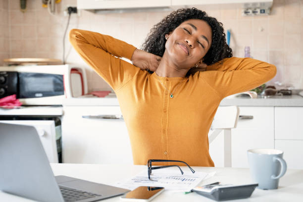 istock Tired black woman working from home stretching at desk 1390050940