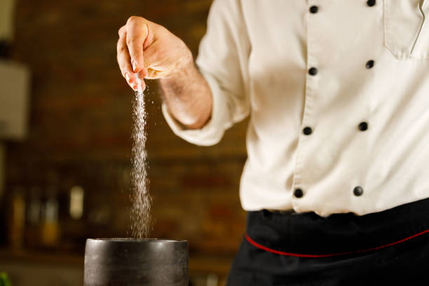 istock Close up of a chef adding salt into his recipe. 1390051113