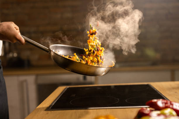 Unrecognizable man cooking healthy vegetarian meal in the kitchen.