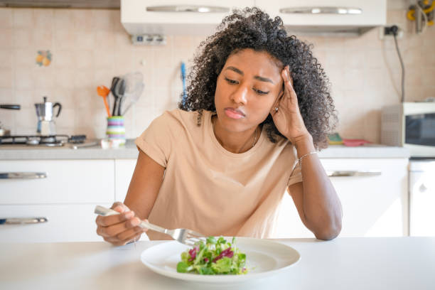 one black woman feeling hungry eating poor calories food for diet - female emotional stress african ethnicity loss imagens e fotografias de stock