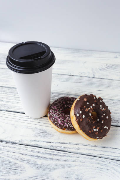 istock white glass with coffee on a light wooden background with donuts 1390053451