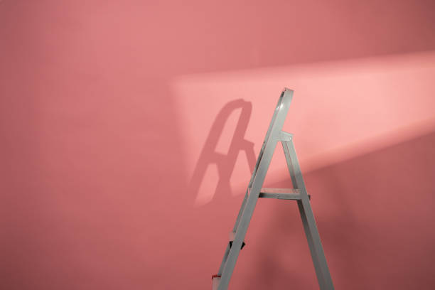 White ladder against pink background stock photo
