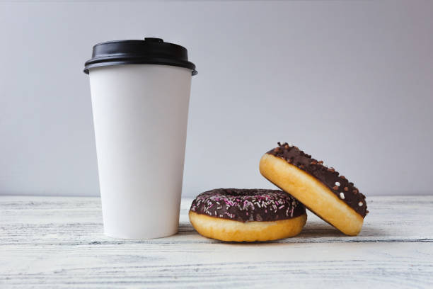 istock white glass with coffee on a light wooden background with donuts 1390053528