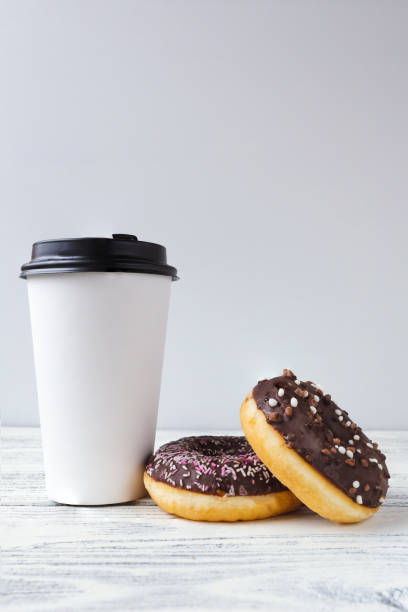 istock white glass with coffee on a light wooden background with donuts 1390053540