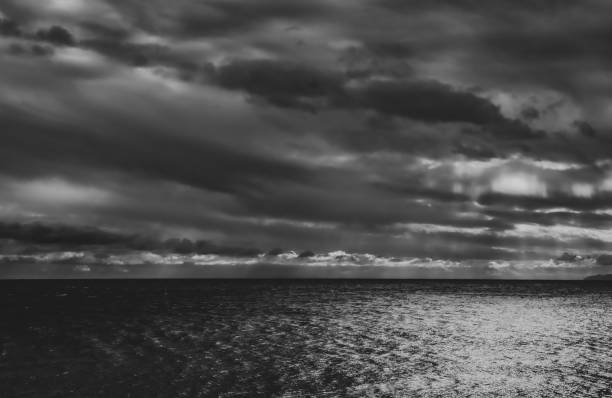 istock Black and white moody sky over sea surface 1390053851