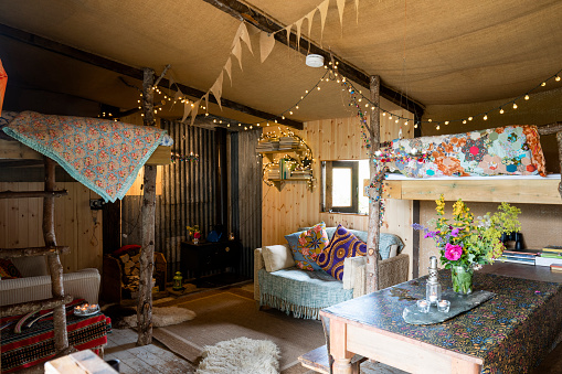 Wide shot of an interior of a log cabin in the North East of England. It has a rustic design with bunting and fairy lights hanging from the ceiling.