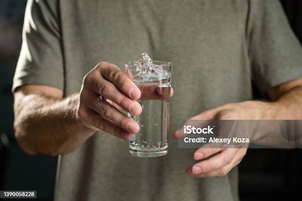 Tremor Of The Hands When Trying To Drink Water Splashes From A Glass In The Hand Of A Man With Tremors Parkinsons Disease Stock Photo - Download Image Now