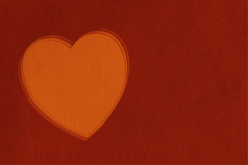 An orange or peach coloured heart over maroon grunge background and empty or blank space all around. Apt for love, valentine's day, Anniversary Greeting cards, backdrops, banners or posters with copy space for text.