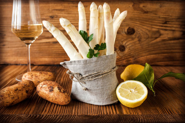 White asparagus with ingredients Bunch of white asparagus with ingredients on rustic wood. Background for a seasonal gastronomy concept with space for text asparagus stock pictures, royalty-free photos & images