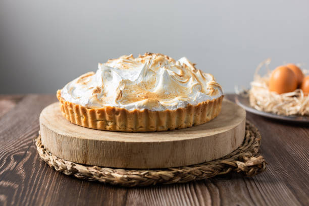 istock Lemon pie on top of log and wooden table. front view 1390064507