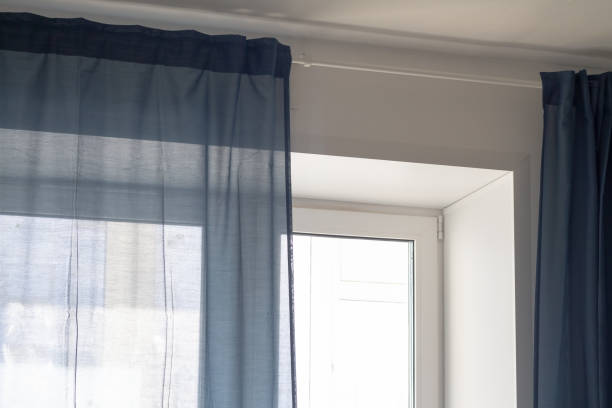 istock Bright sunlight from the window passes through the blue curtain 1390065808