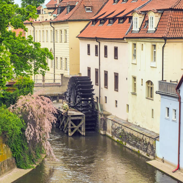 ruota idraulica in un ruscello nel centro storico di praga, repubblica ceca - water wheel foto e immagini stock