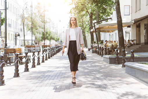 casual young woman walking along a city street. photo with a copy space.