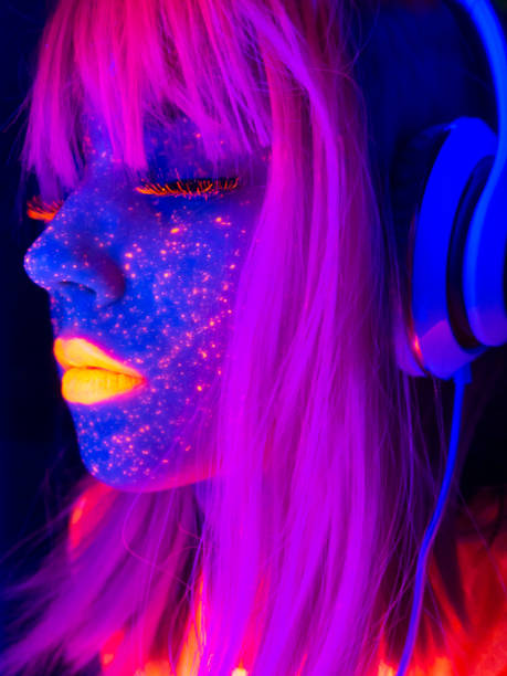 hermosa mujer con luces de neón disfrutando escuchando la música - face paint audio fotografías e imágenes de stock