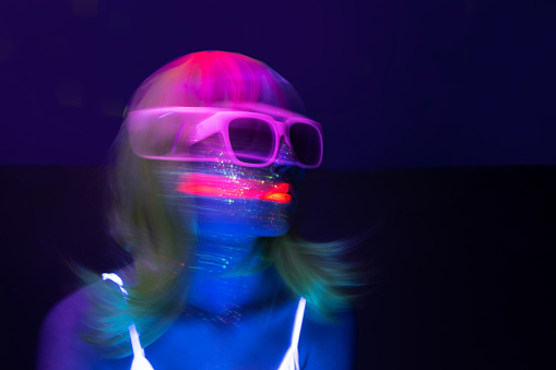 Light painting portrait of a young woman with eyeglasses. New art direction, long exposure photo without processing, light drawing at long exposure.