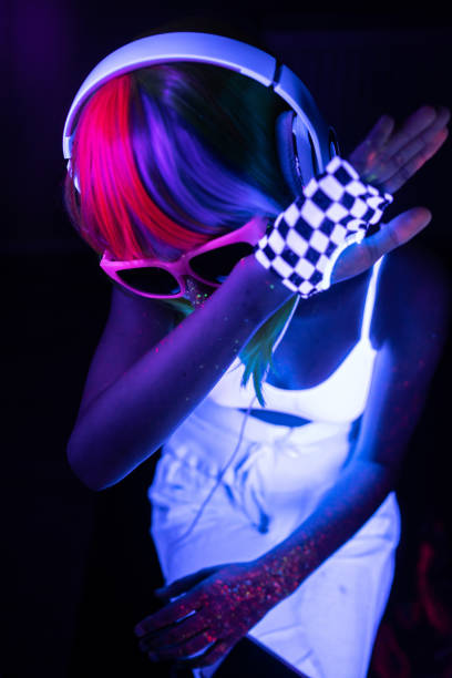 młoda dj-ka ukrywa twarz pod wpływem światła uv - face paint audio zdjęcia i obrazy z banku zdjęć