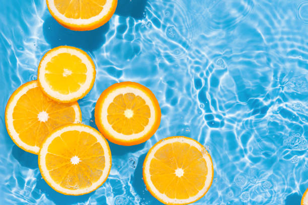 istock Creative summer composition made of sliced orange in transparent pool water. Refreshment concept. Healthy refreshing drink theme. Top view 1390069559