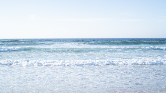 Algarve ocean waves. Small coast waves. Seafoam lines. Abstract sea background. Blue ocean backdrop. High quality photo