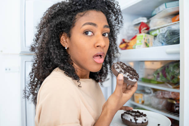 istock One black woman snacking tempted by sugar sweeties 1390071210