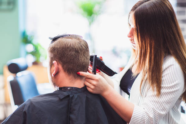 理髪店で男性の髪を切る美容師の女性 - men hairdresser human hair hairstyle ストックフォトと画像