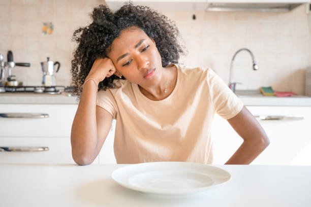 One black woman feeling hungry eating poor calories food for diet Bored back woman dieting and eating poor calories food low quality of life stock pictures, royalty-free photos & images