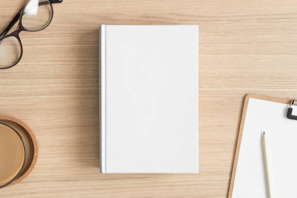 istock White book mockup with workspace accessories on the wooden table. 1390072639