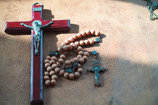 crucifix cross on the brown leather in Nature sun light for background and inspiration