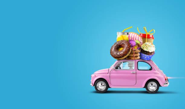 Pink retro toy car with Cakes, sweets, pastries a top on a blue background