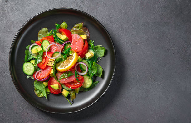 istock Vegetable salad with salmon and avocado on a dark background 1390073915