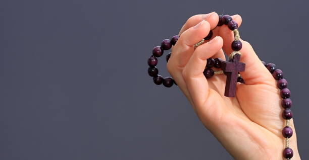 istock hand holding cross praying to god 1390074130