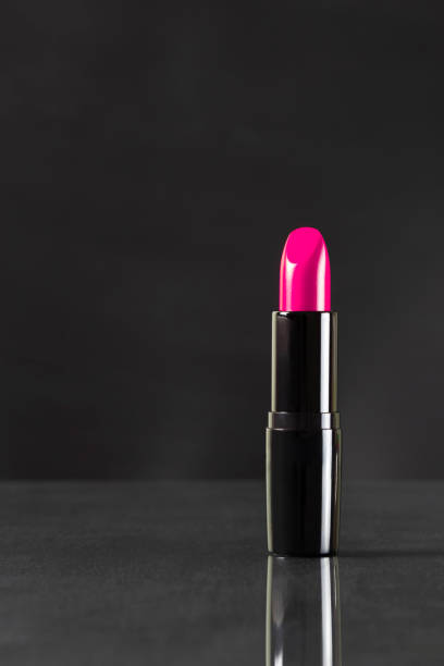 istock Pink lipstick open to demonstration color on black background. Makeup.Vertical layout 1390076125