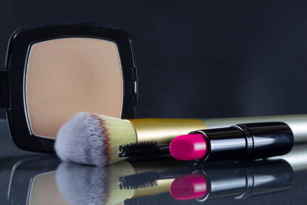 Lipstick mascara powder brushon on black background. Makeup.