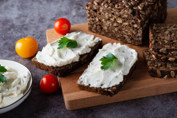 istock Rye bread with cream cheese on grey table. Whole grain rye bread with seeds 1390077442