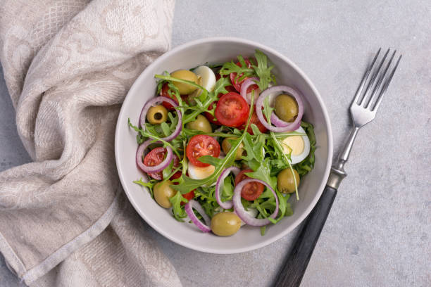 istock Salad with fresh arugula, cherry tomatoes, quail egg, onion and green olives 1390080481