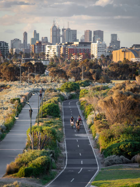 Melbourne, Australia - March 31, 2022: People cycling with Melbourne skyline on the background.