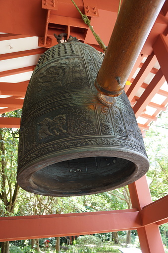 A brass bell hangs in front of the monastery building