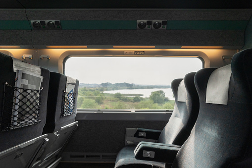 Unoccupied seats on train with view through window.