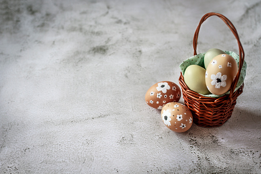 Easter eggs basket on concrete table. Copy space. Greeting card. Top view.