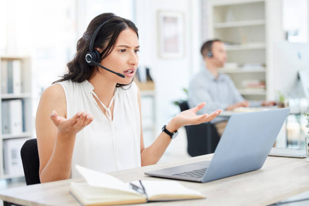 istock Shot of a young call centre agent looking annoyed while working on a laptop in an office 1390082397
