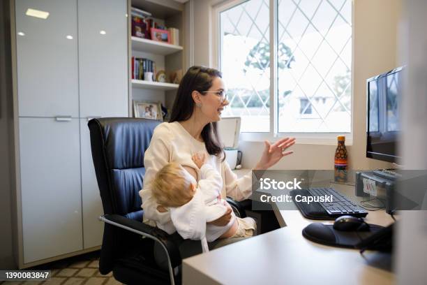 Foto de Mãe Amamentando Bebê Enquanto Trabalhava Em Casa e mais fotos de stock de Amamentação - Amamentação, Escritório, Trabalhar