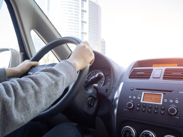 Hand Holding a Steering Wheel Driving Hand Holding a Steering Wheel Driving car city urban scene commuter stock pictures, royalty-free photos & images